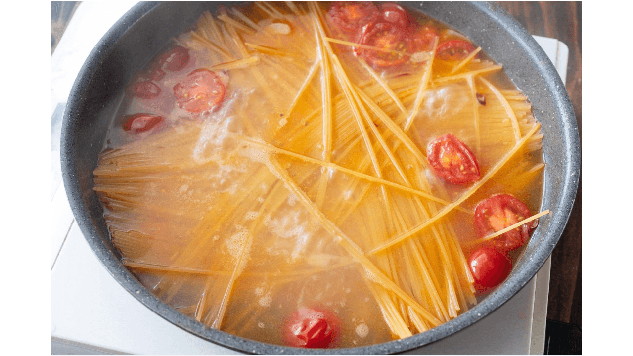 フライパンに水と塩とを加え、パスタを茹でている様子