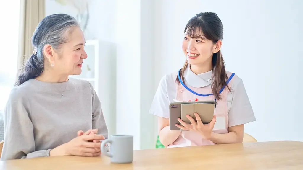 質問を受けるグレーの服を着た介護サービス利用者