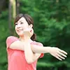 ピンクのシャツを着てストレッチをしている