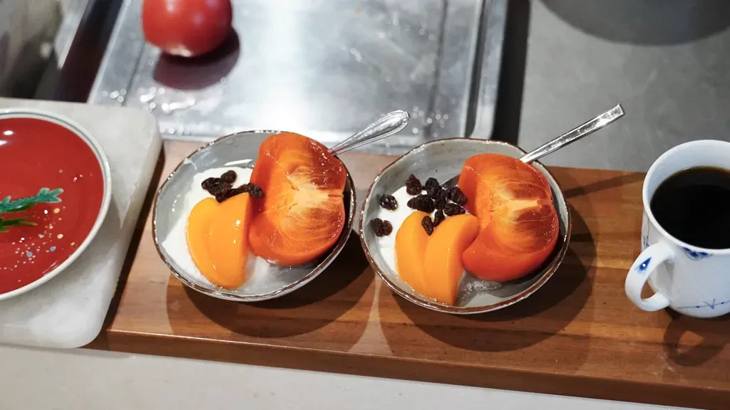 お皿にのった柿とコーヒー