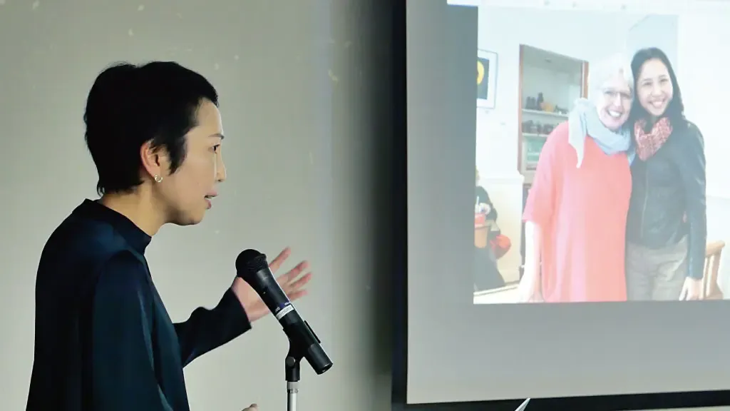 スライドを見ながら話をするスローショッピング・ジャパン事務局の田中さん